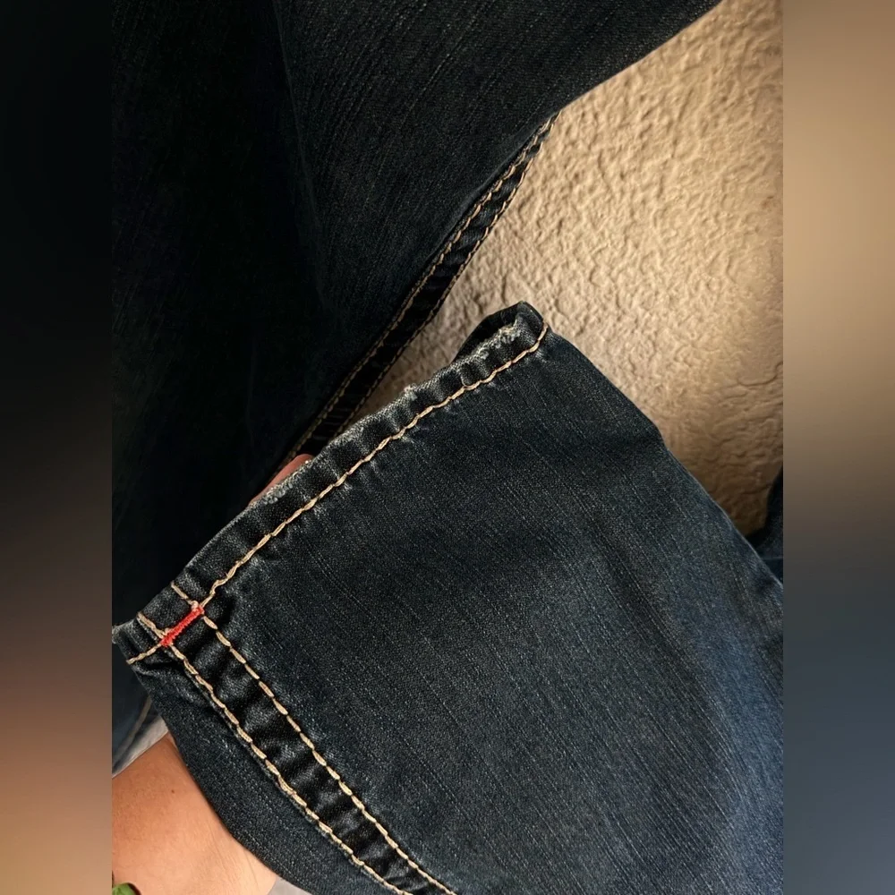 True Religion jeans feature a dark wash and bold signature stitching. Skinny